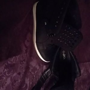 Black leather look sneakers with interior wedge.